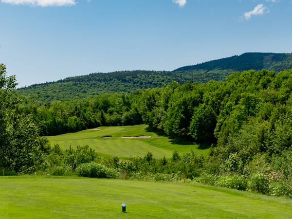 The sun setting along a green at the Sunday River Golf Club.