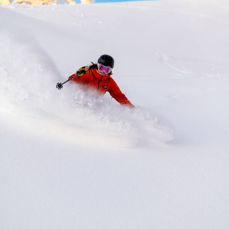 A person skiing in powder at Sunday River.