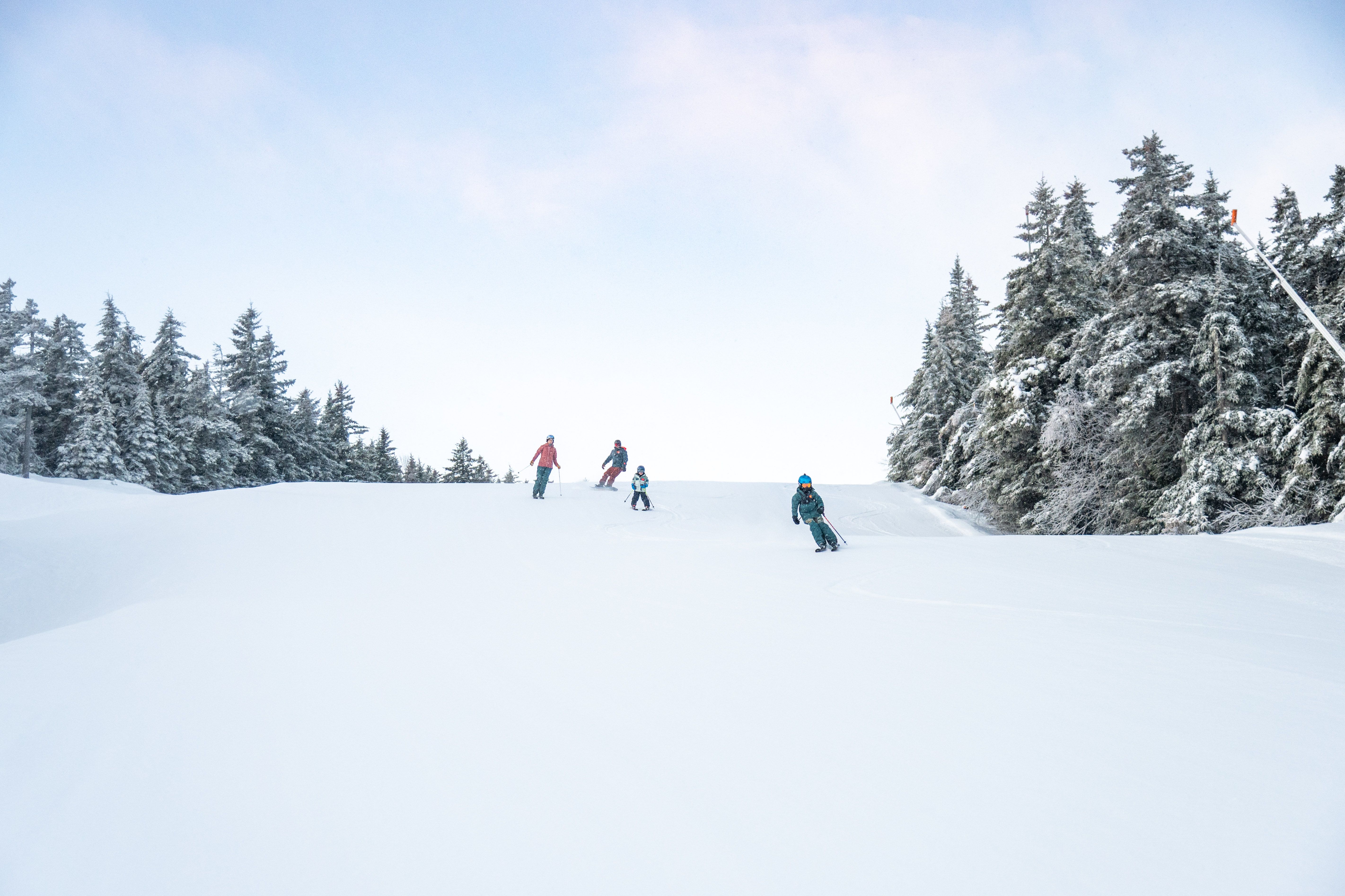 A family skiing down a trail at Sunday River.