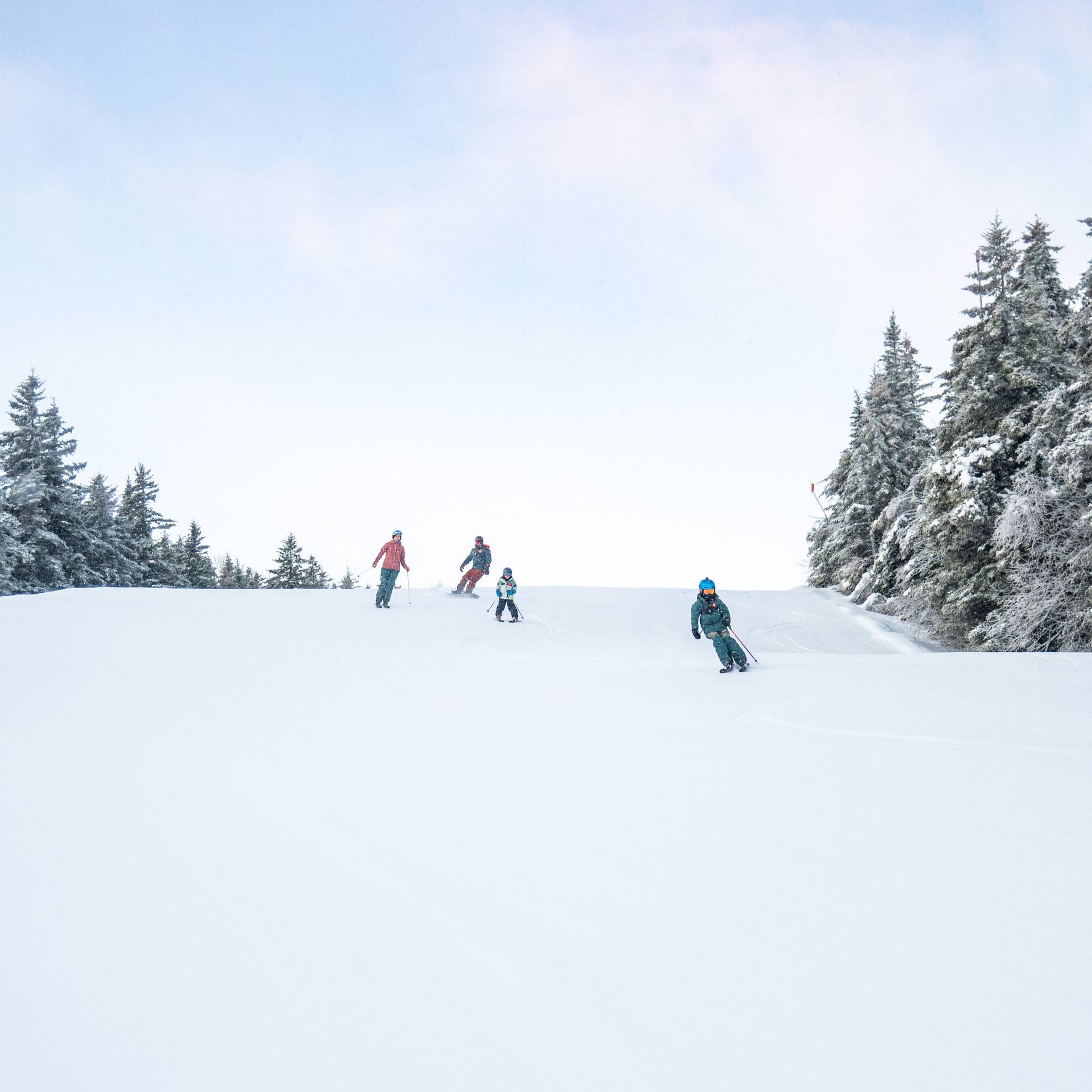 A family skiing down a trail at Sunday River.