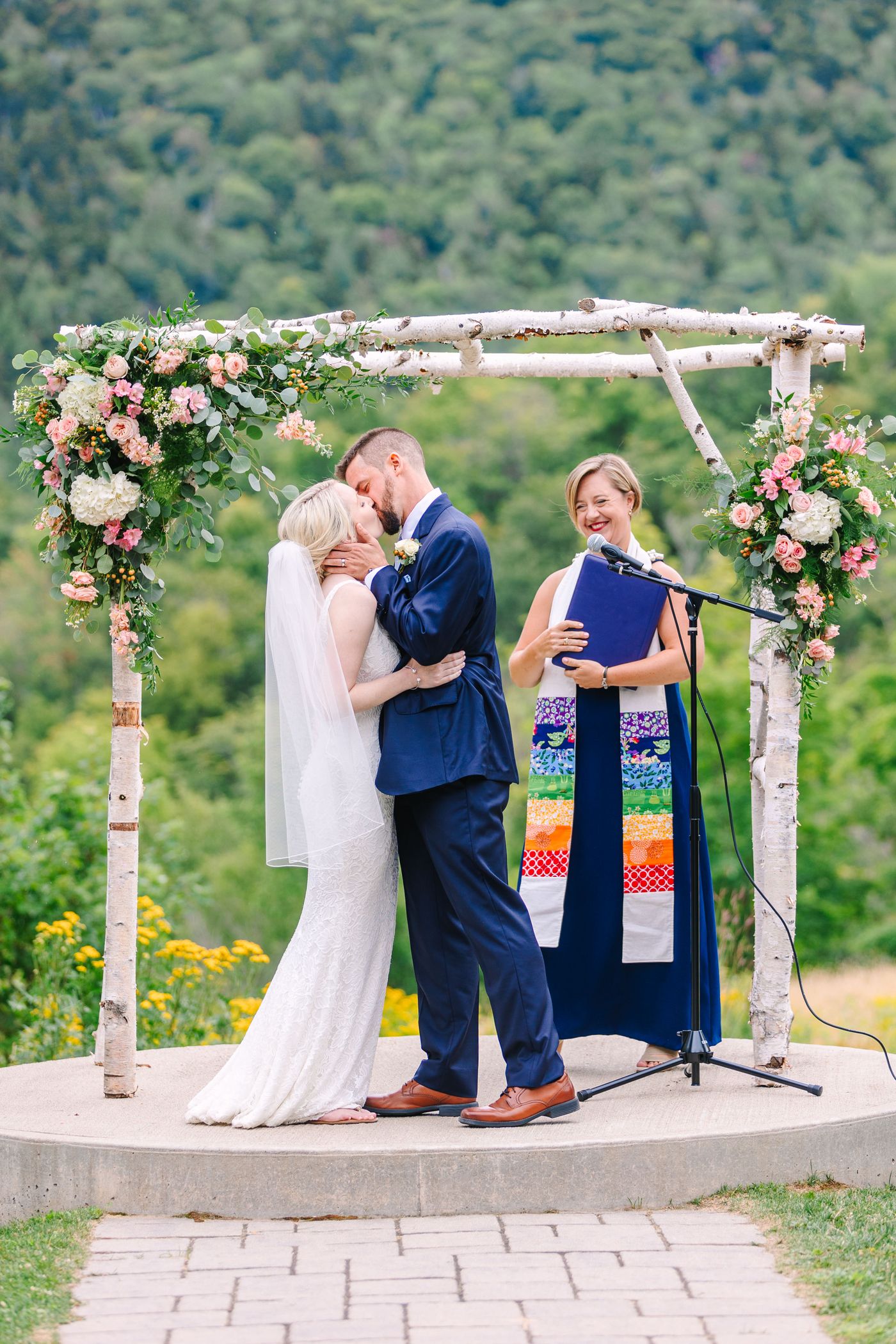 A bride and groom kissing at the alter.