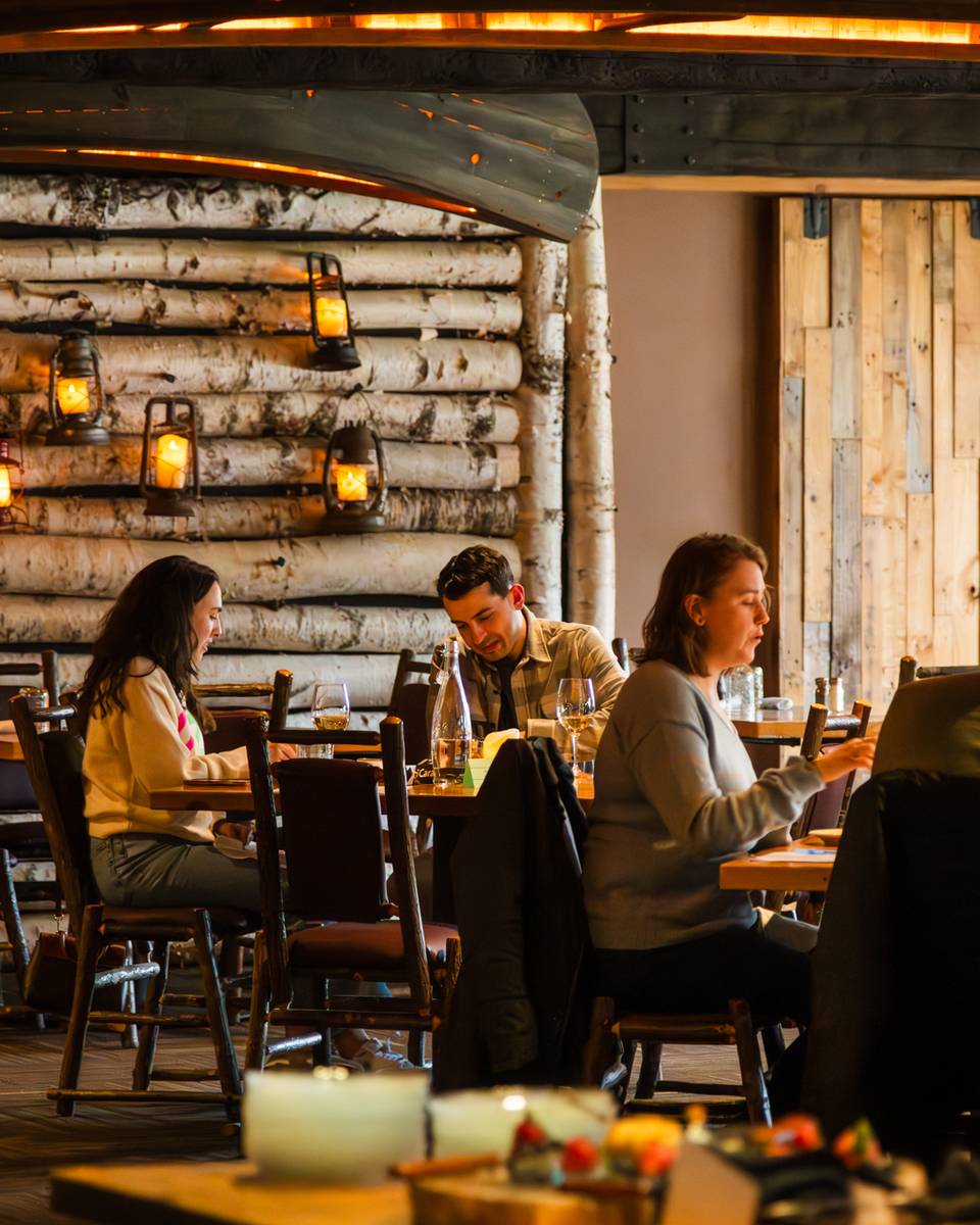 A group of people sitting at Camp eating their dinner at Sunday River.