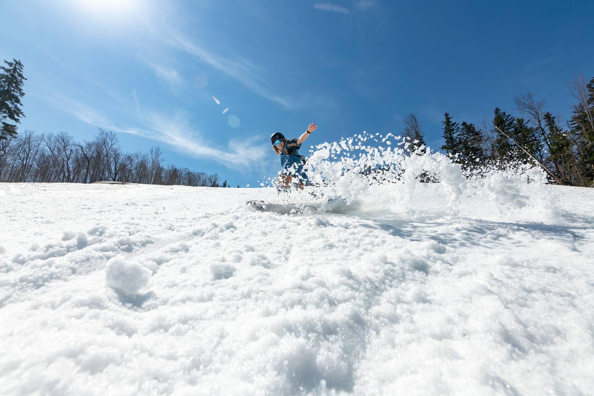 A snowboarder shredding in the spring at Sunday River.
