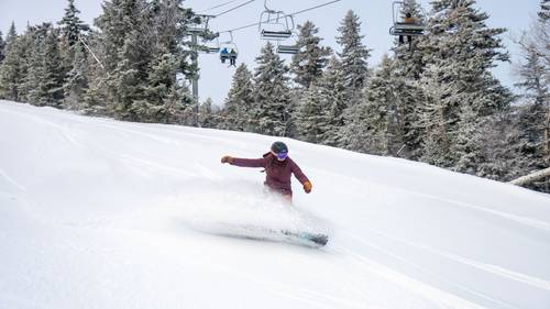 A person snowboarding at Sunday River.