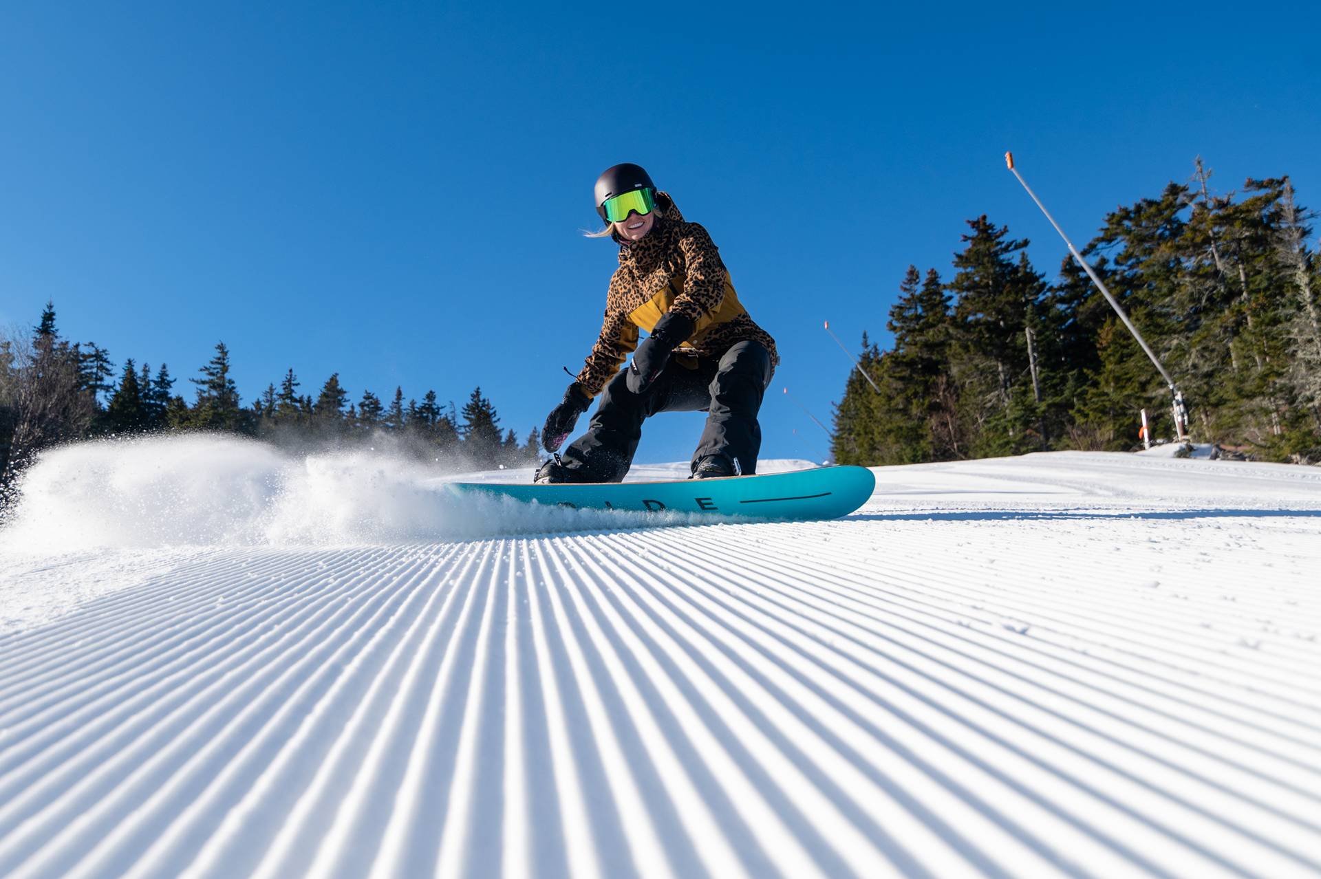 A snowboarder on fresh corduroy at Sunday River.