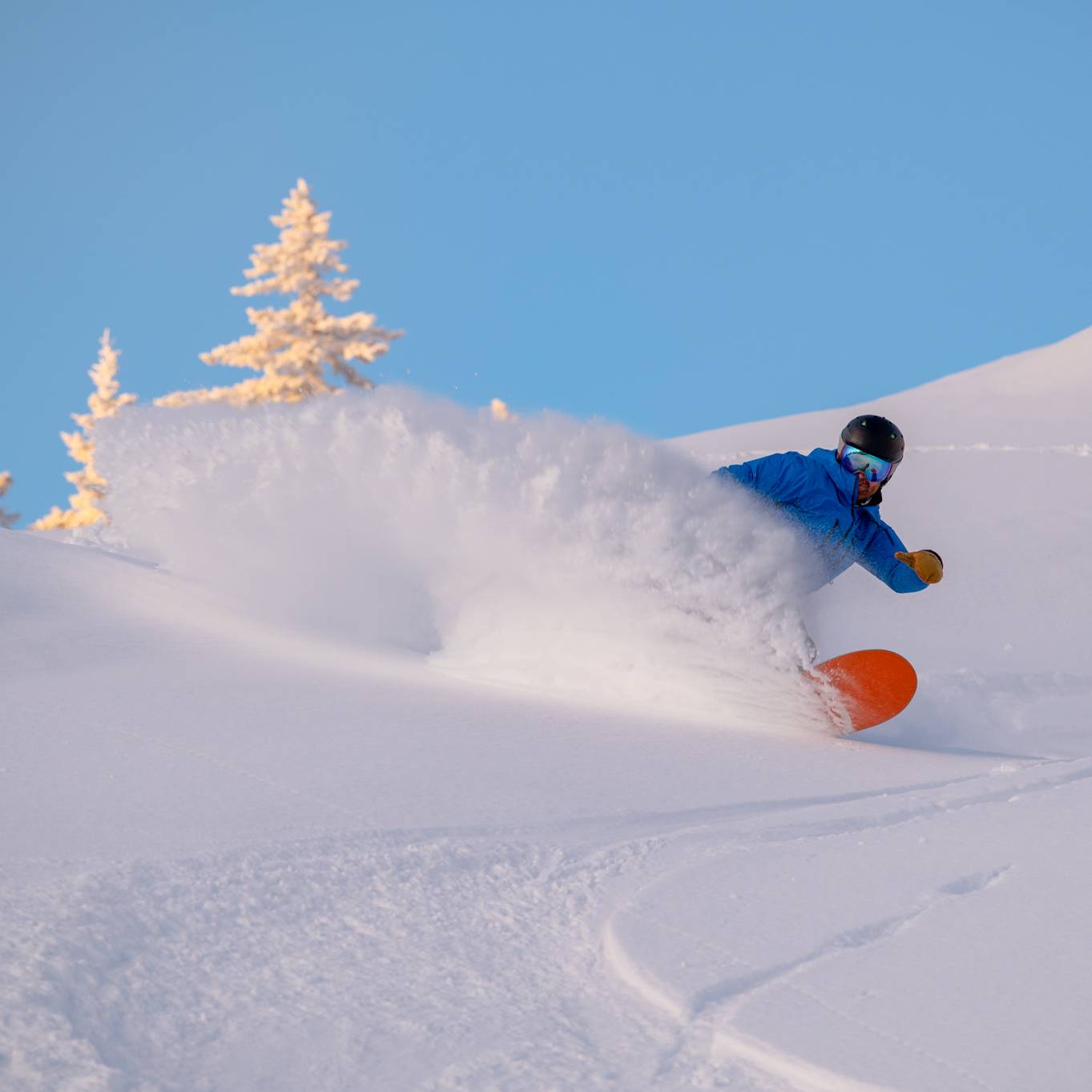 A snowboarder cruising in powder at Sunday River.