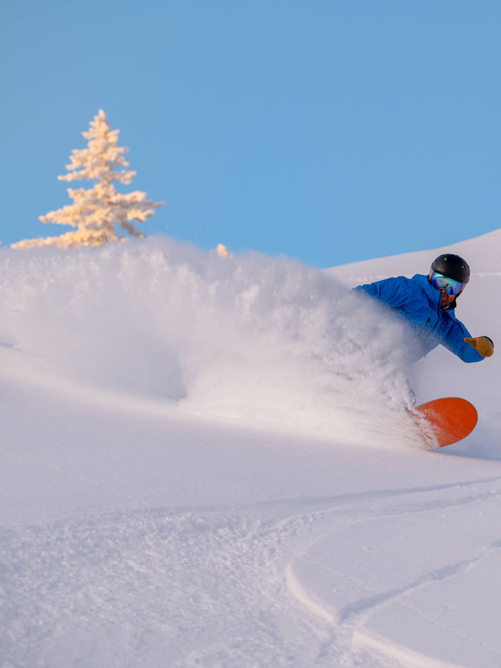 A snowboarder cruising in powder at Sunday River.