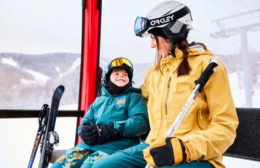A child and woman sitting in a Chondola cabin at Sunday River.