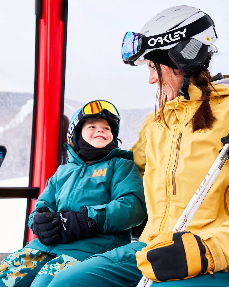 A mom and son sitting in the chairlift at Sunday River.