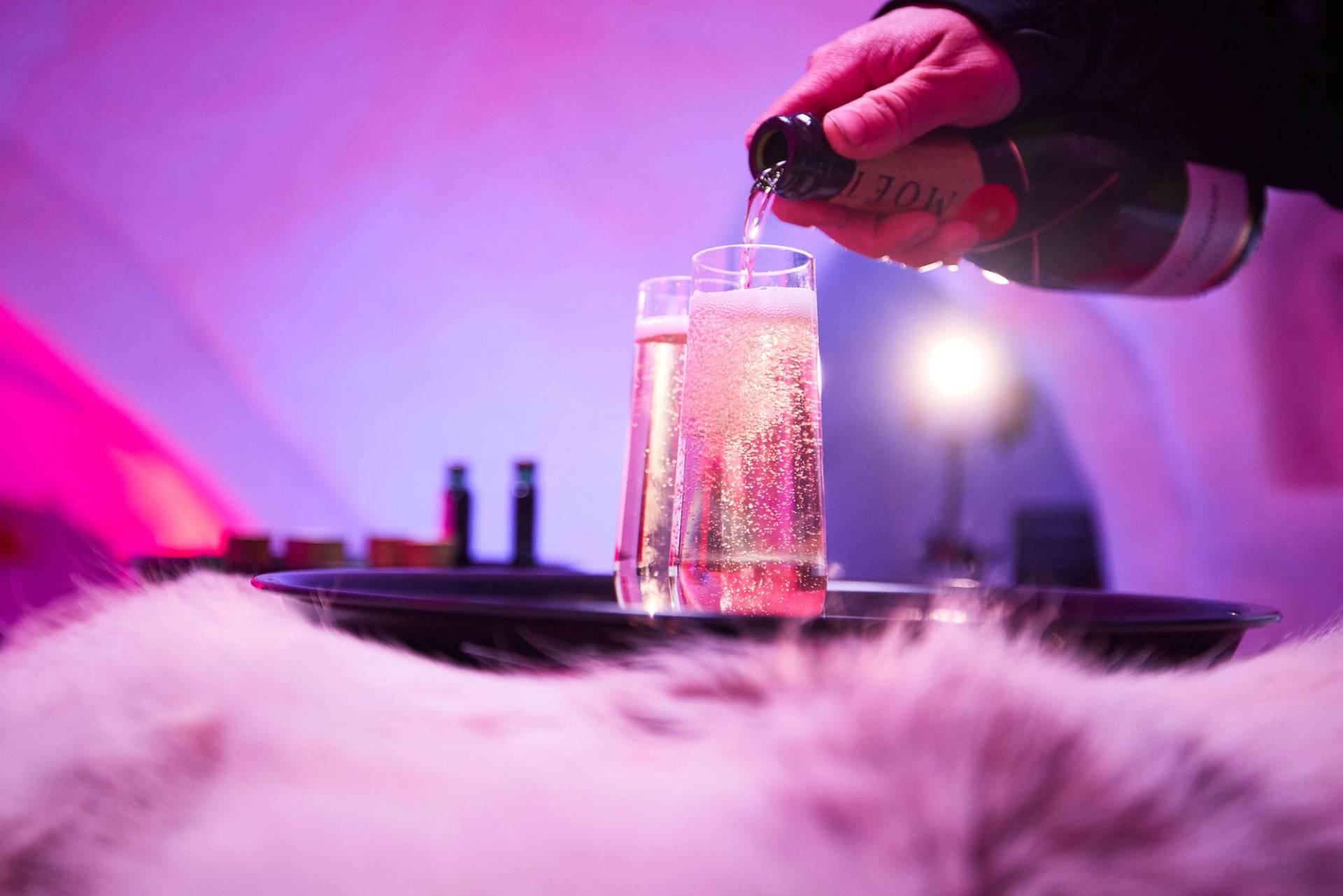 A person pouring champagne at the Iglu at Sunday River.