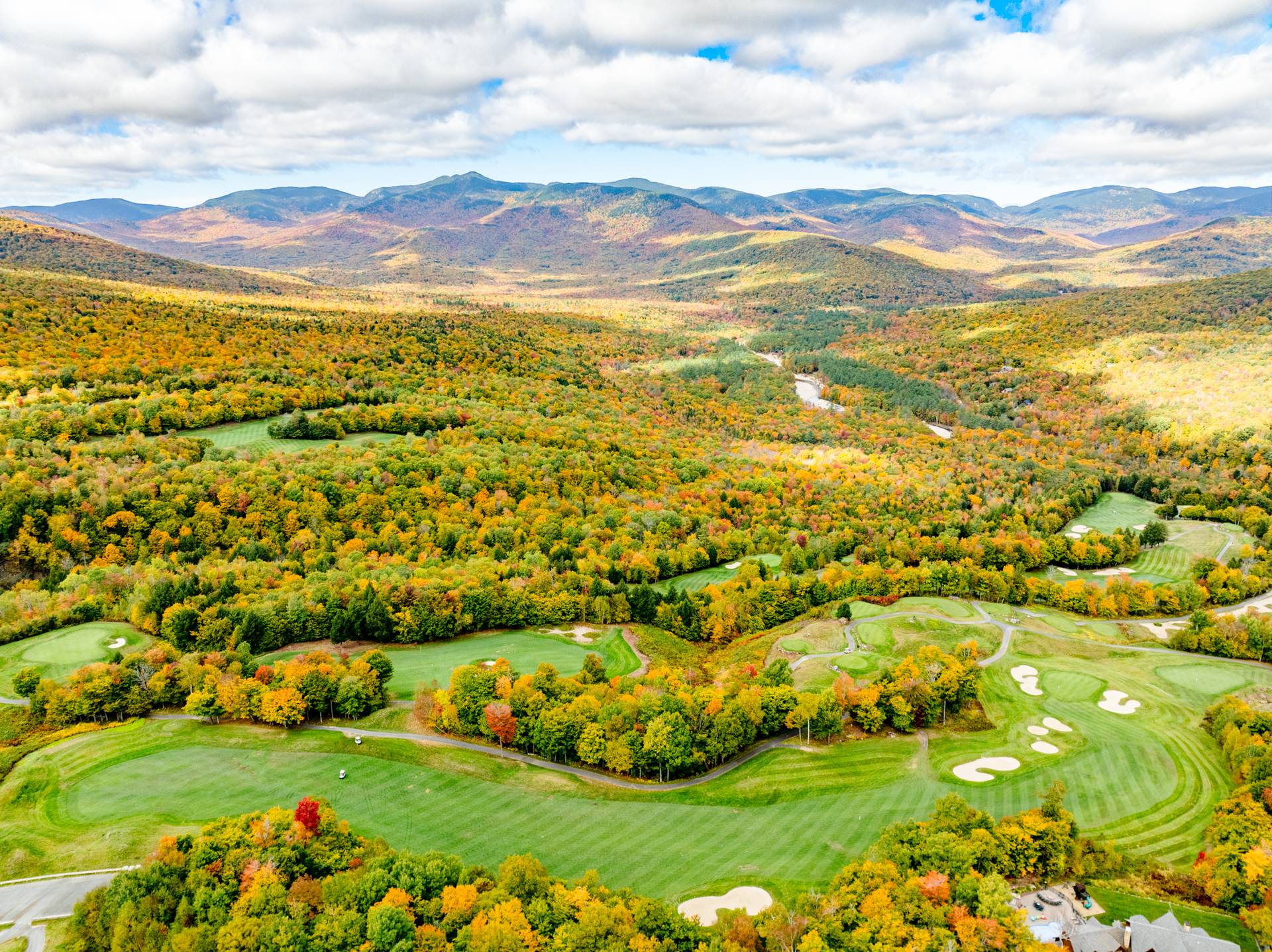 An aerial view of the Sunday River Golf Club in the fall with colorful trees.