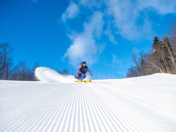 A woman skiing down a trail at Sunday River.