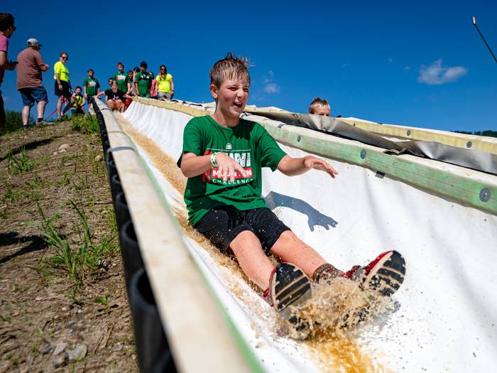 A kid sliding down a water slide at the Mini Mountain Challenge at Sunday River.
