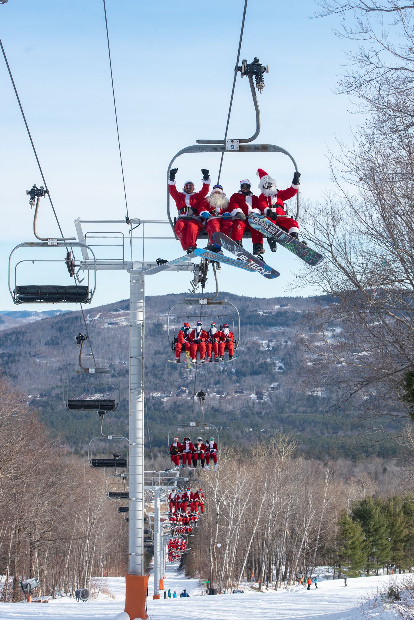 Santas on a chairlift at Sunday River for Santa Sunday.