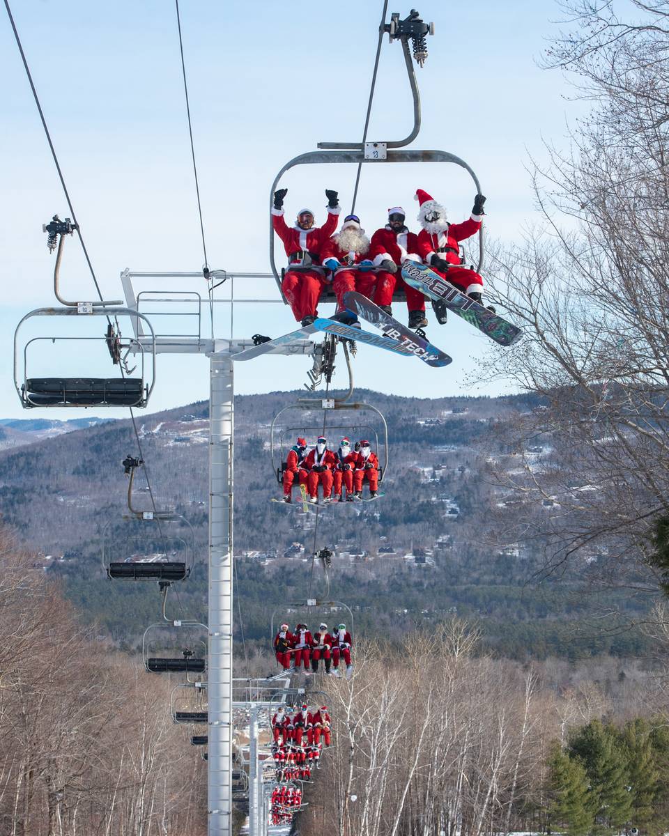 Santas on a chairlift at Sunday River for Santa Sunday.