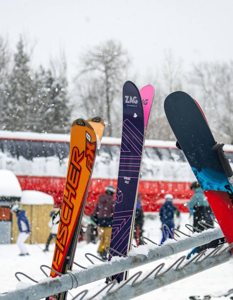 Skis lined up at Sunday River with the Chondola in the background.
