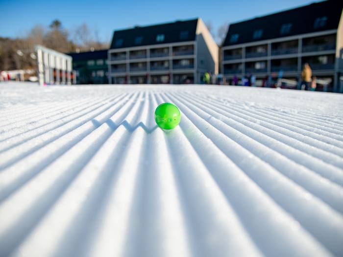 A green Easter egg between laying on fresh corduroy at Sunday River.