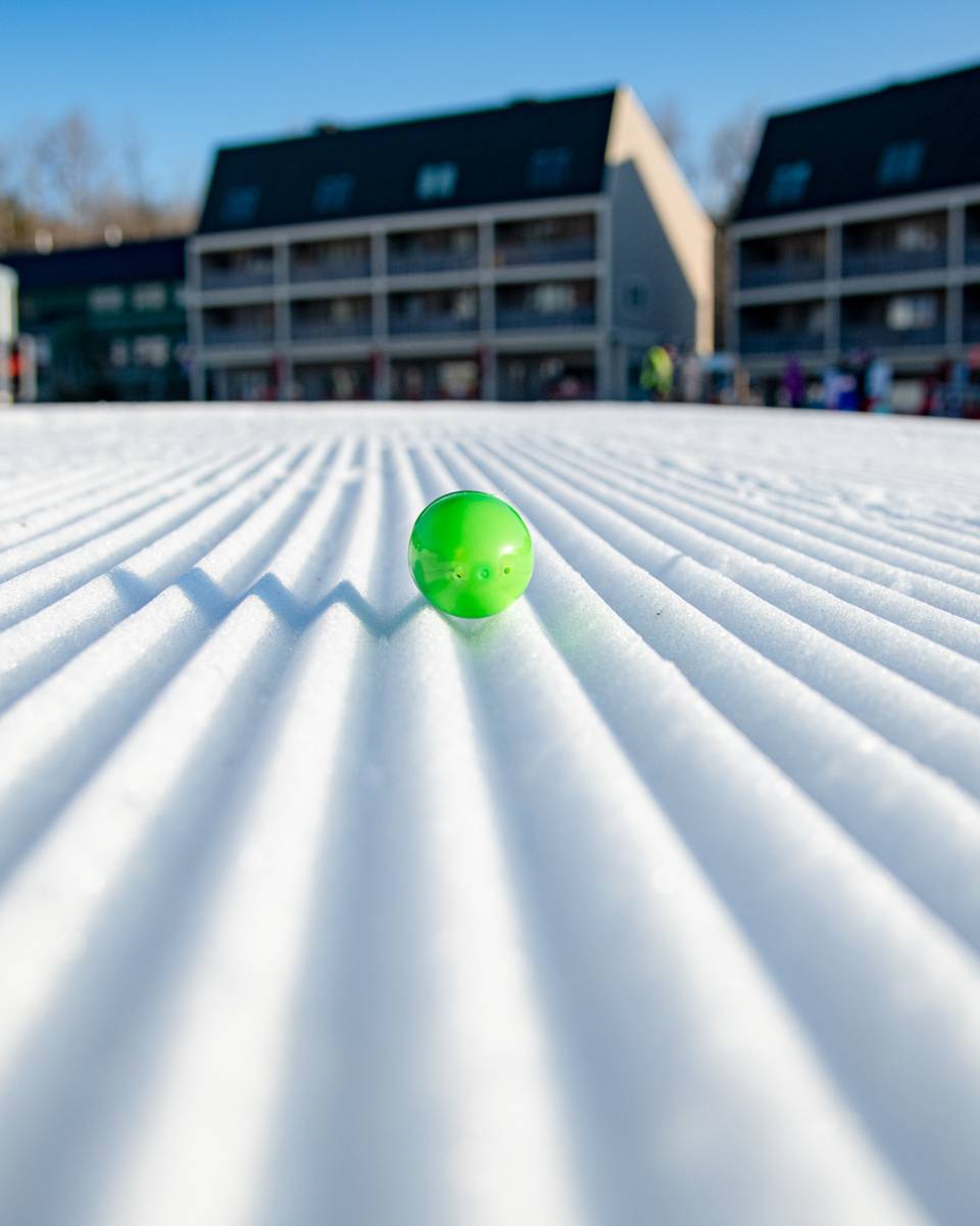 A green Easter egg between laying on fresh corduroy at Sunday River.