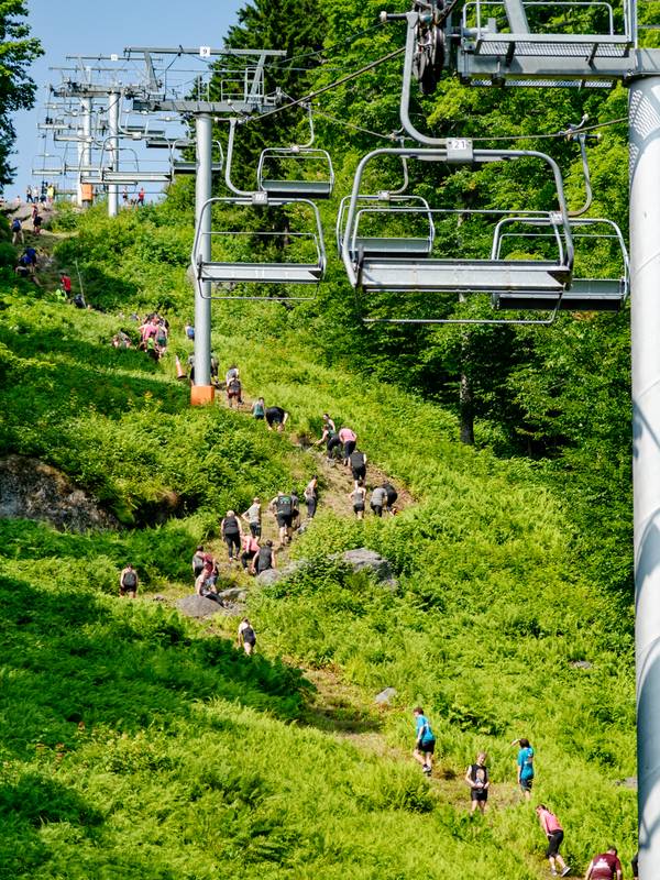 People climbing up a really steep hill at Sunday River's Tough Mountain Challenge.