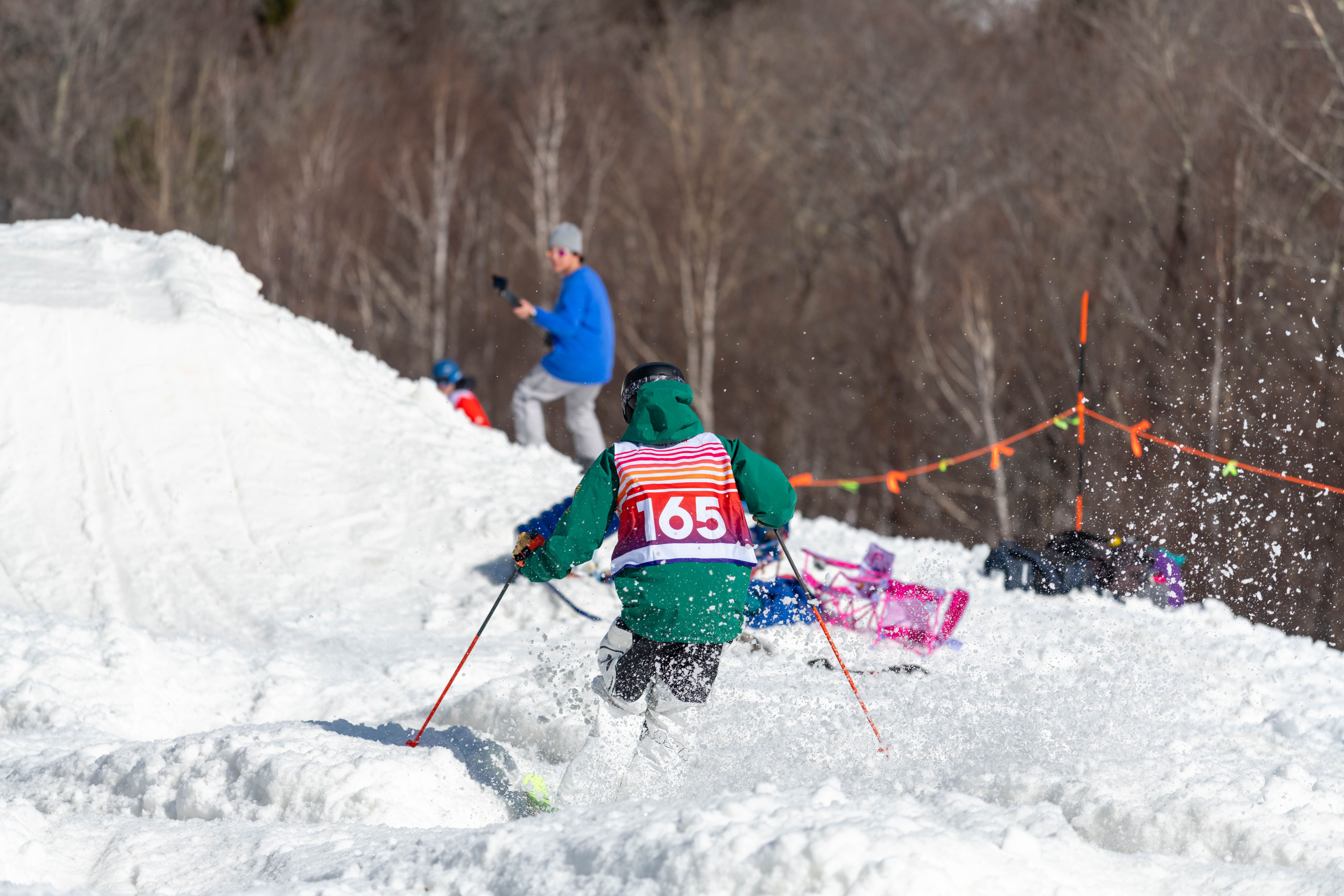 A person where a Bust N Burn bib and skiing the course.