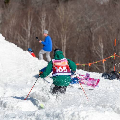 A person where a Bust N Burn bib and skiing the course.