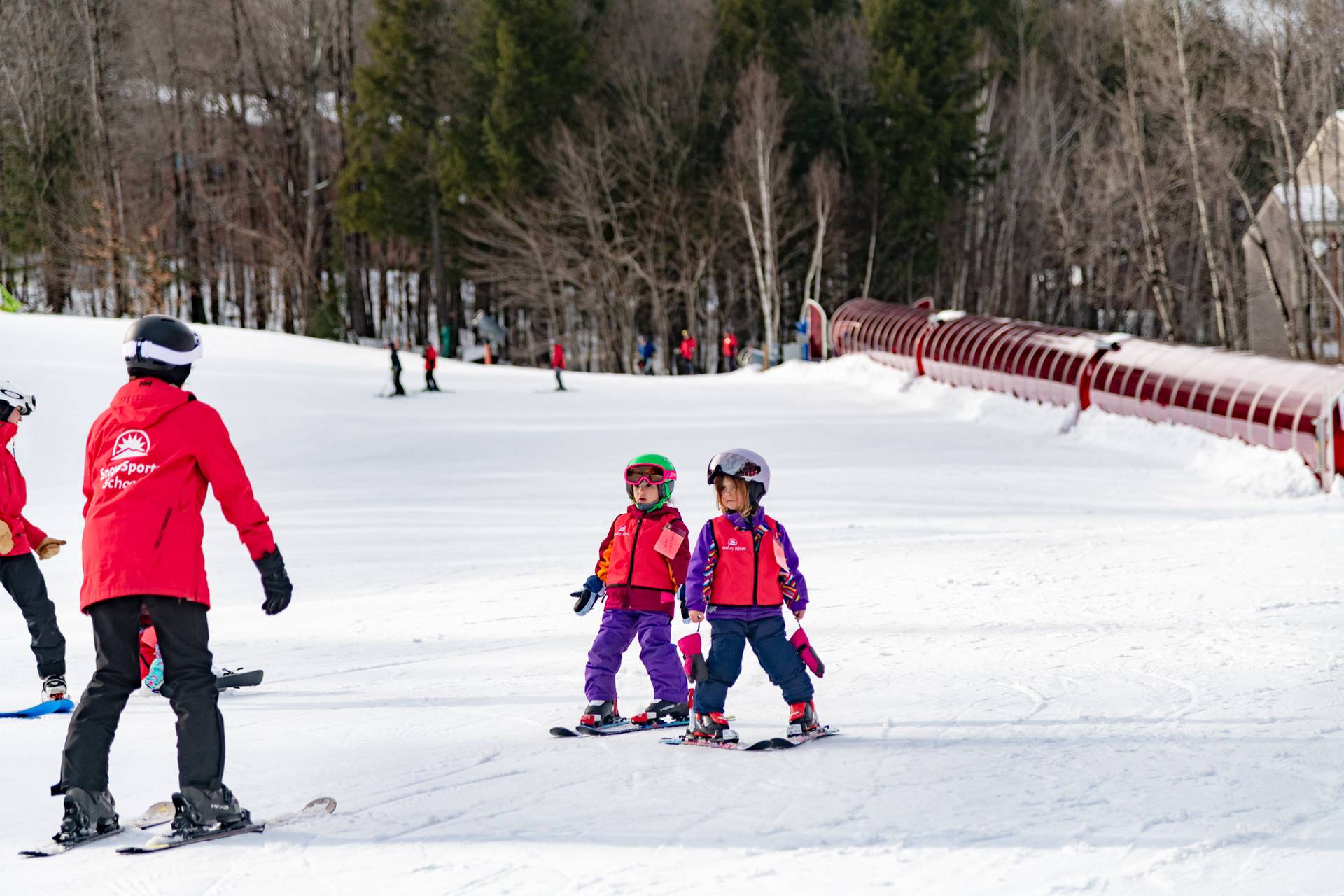 A ski instructor with little kids on a trail at Sunday River.
