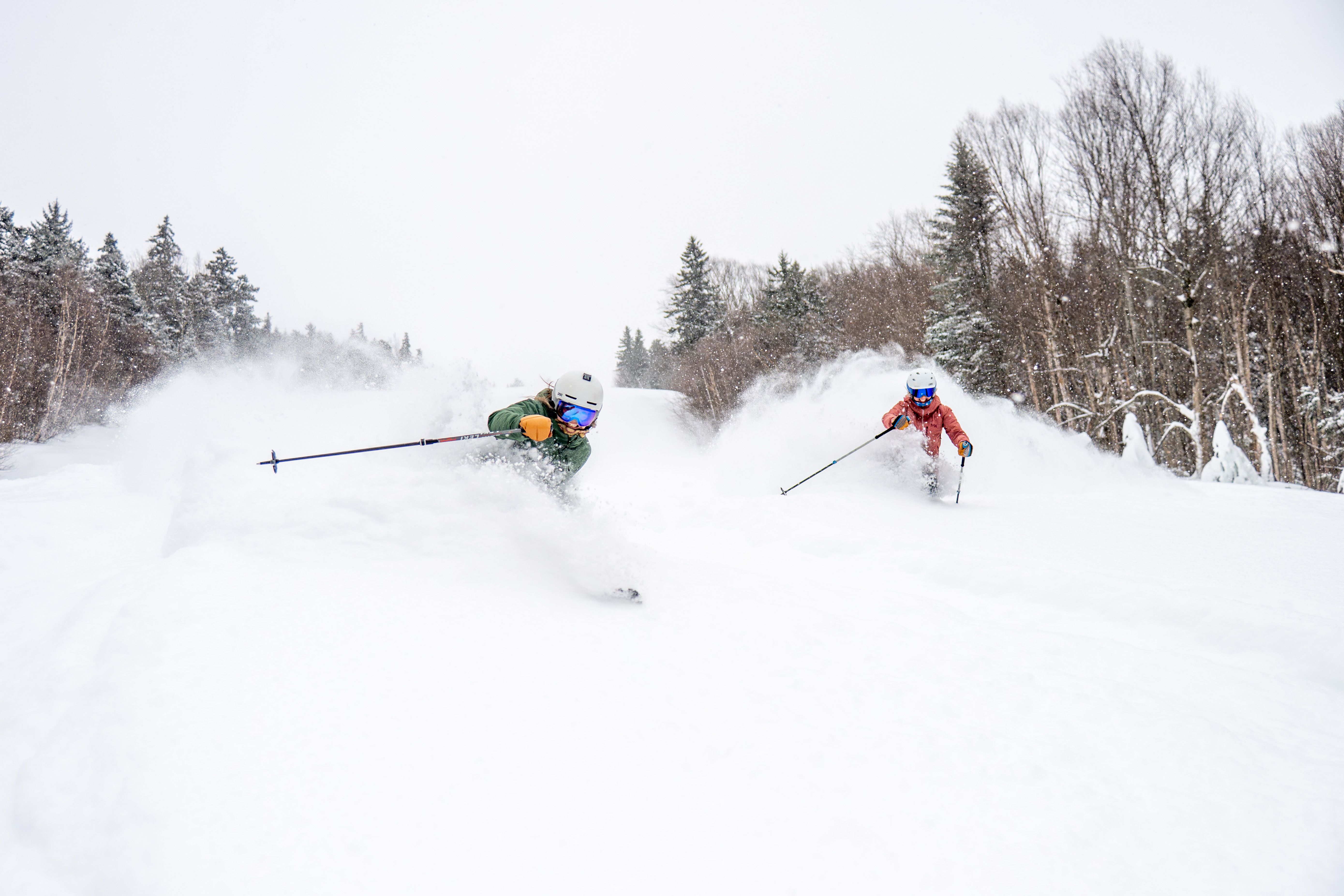 People skiing in fresh powder at Sunday River.