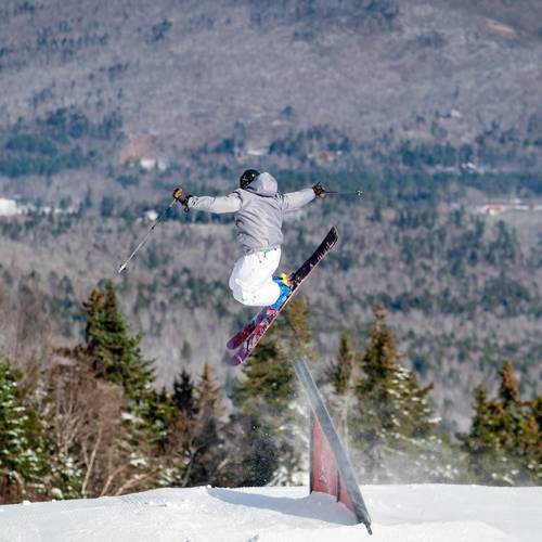 A kid getting air after hitting a jump at Sunday River.
