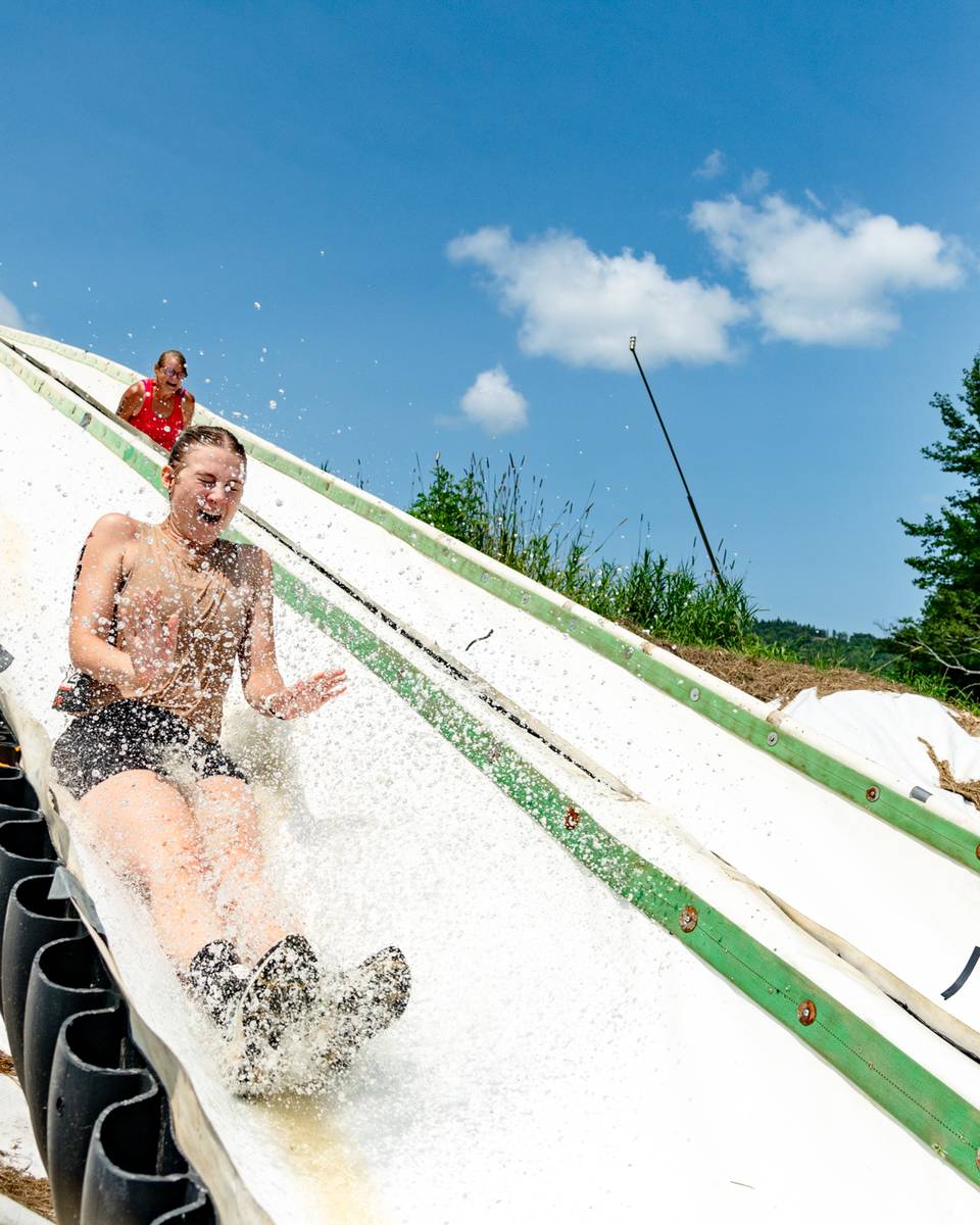 People happy on a water slide at Tough Mountain Challenge.