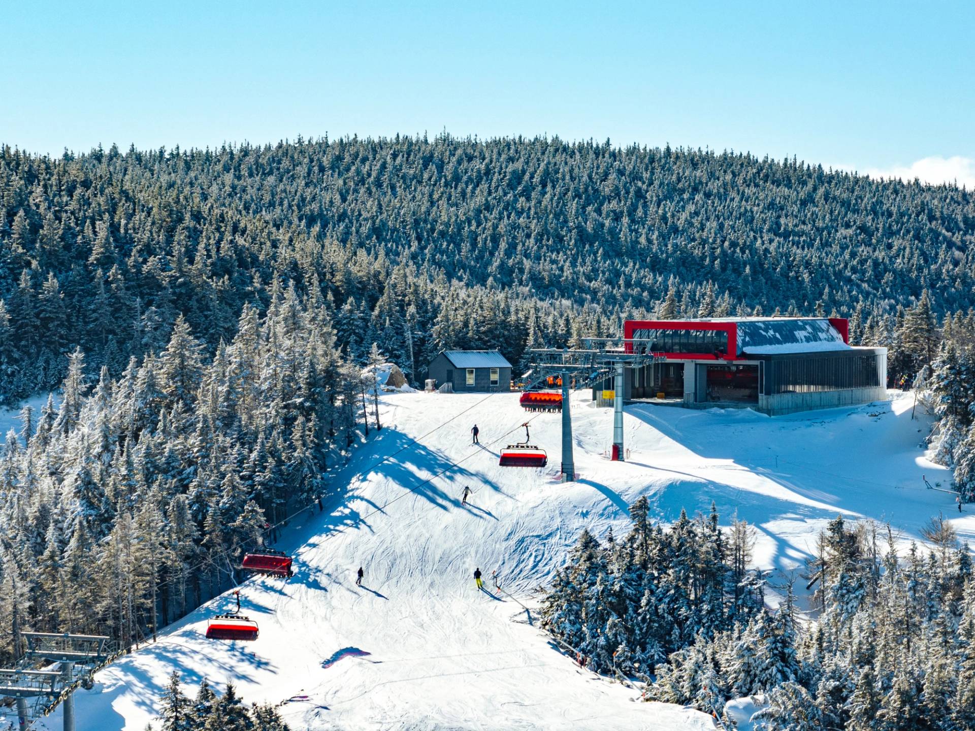Barker 6 at Sunday River with people skiing on the mountain.