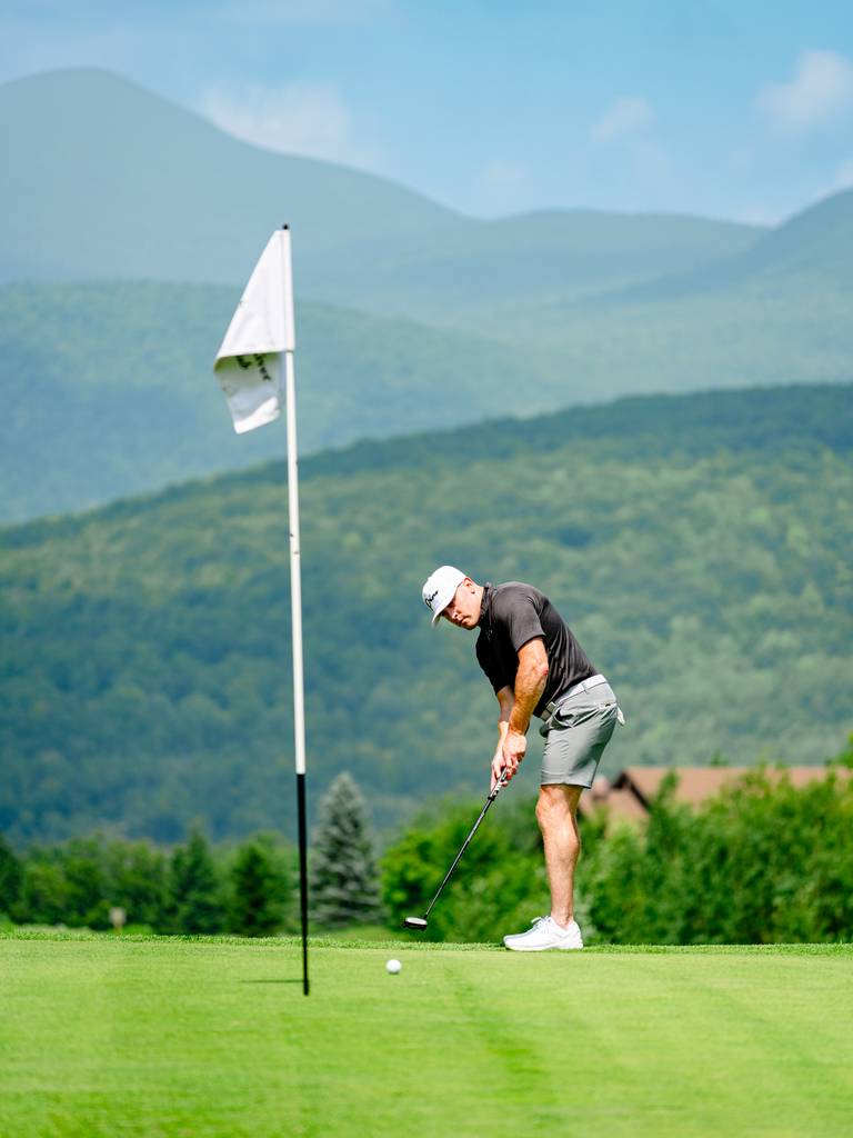Golfer making a putt.