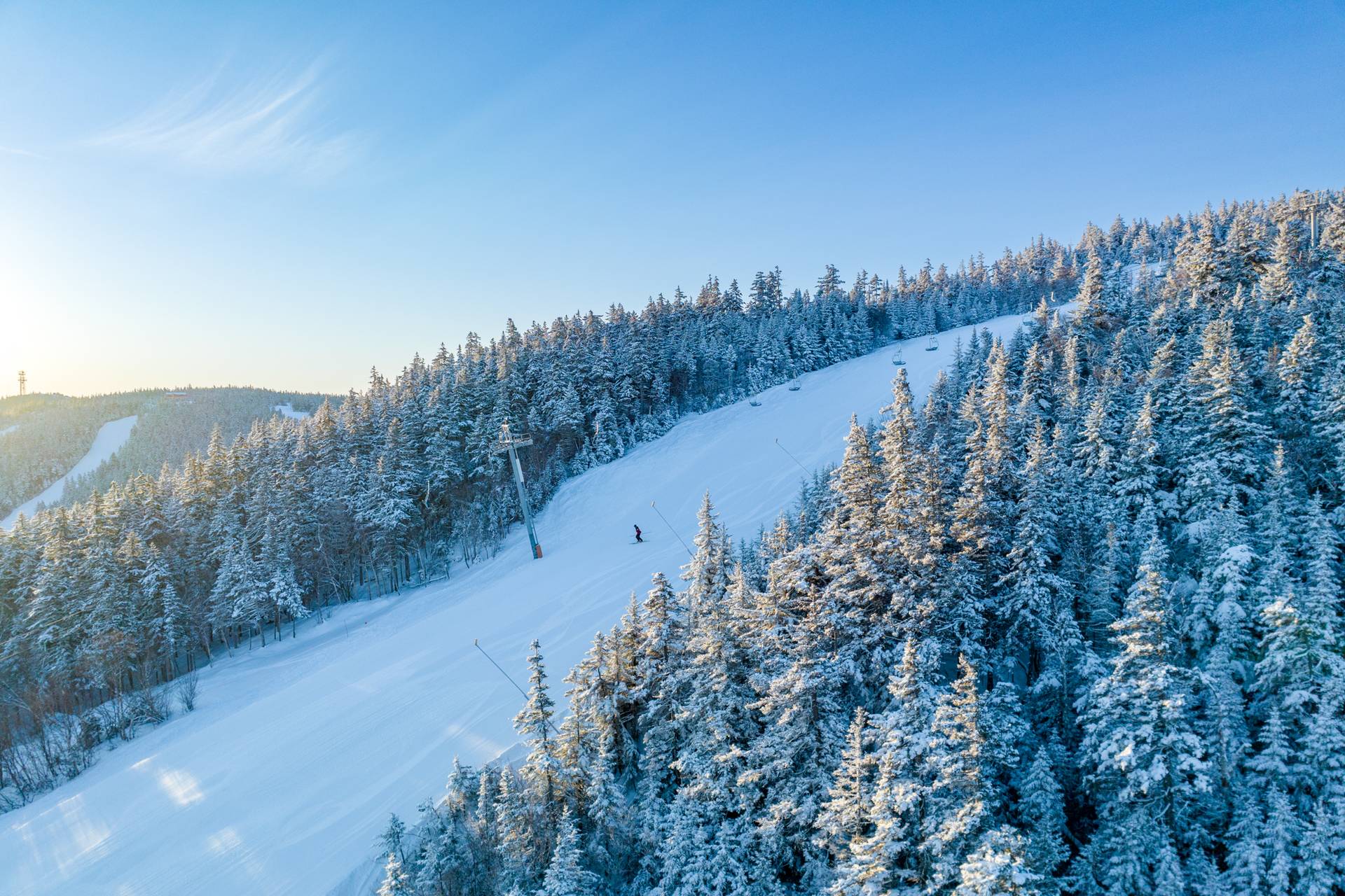 Skiers skiing down a trail at Sunday River in the winter.