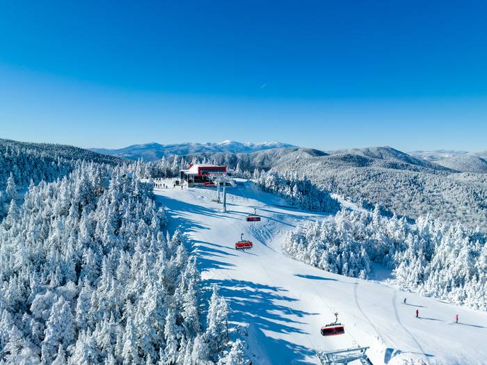 Skiers skiing around Barker 6 chairlift at Sunday River in the winter time.