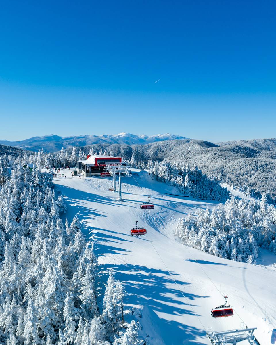 Skiers skiing around Barker 6 chairlift at Sunday River in the winter time.