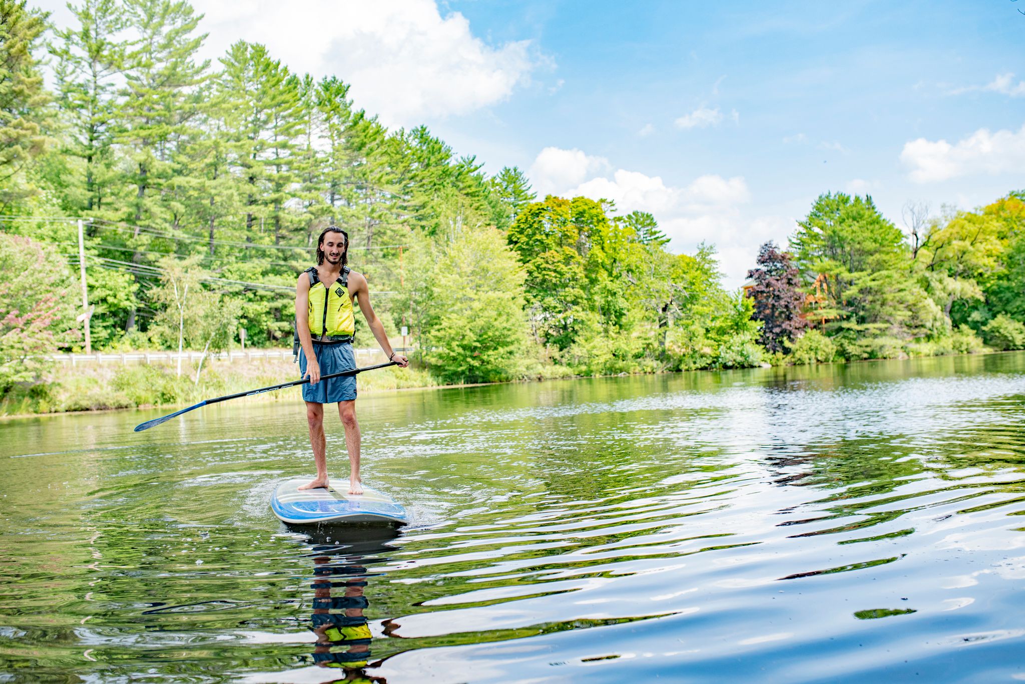 A man standing on a paddleboard in a lake.