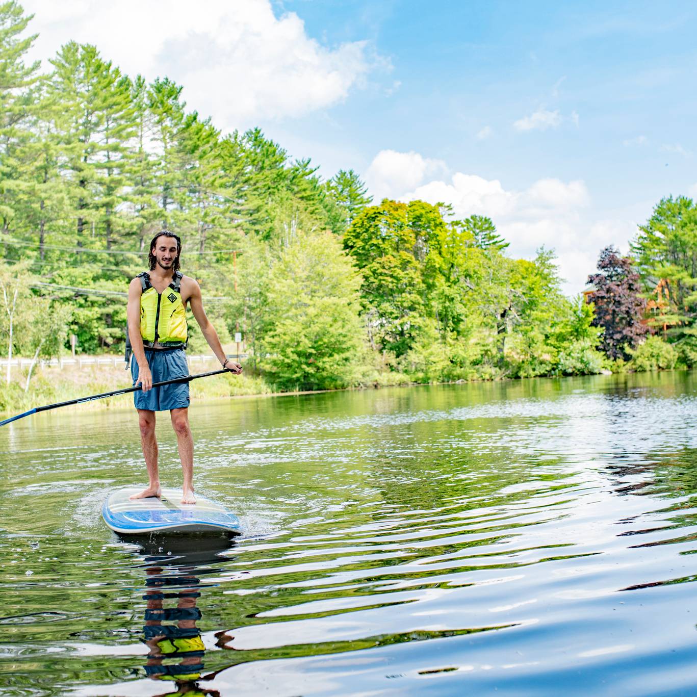 A man standing on a paddleboard in a lake.