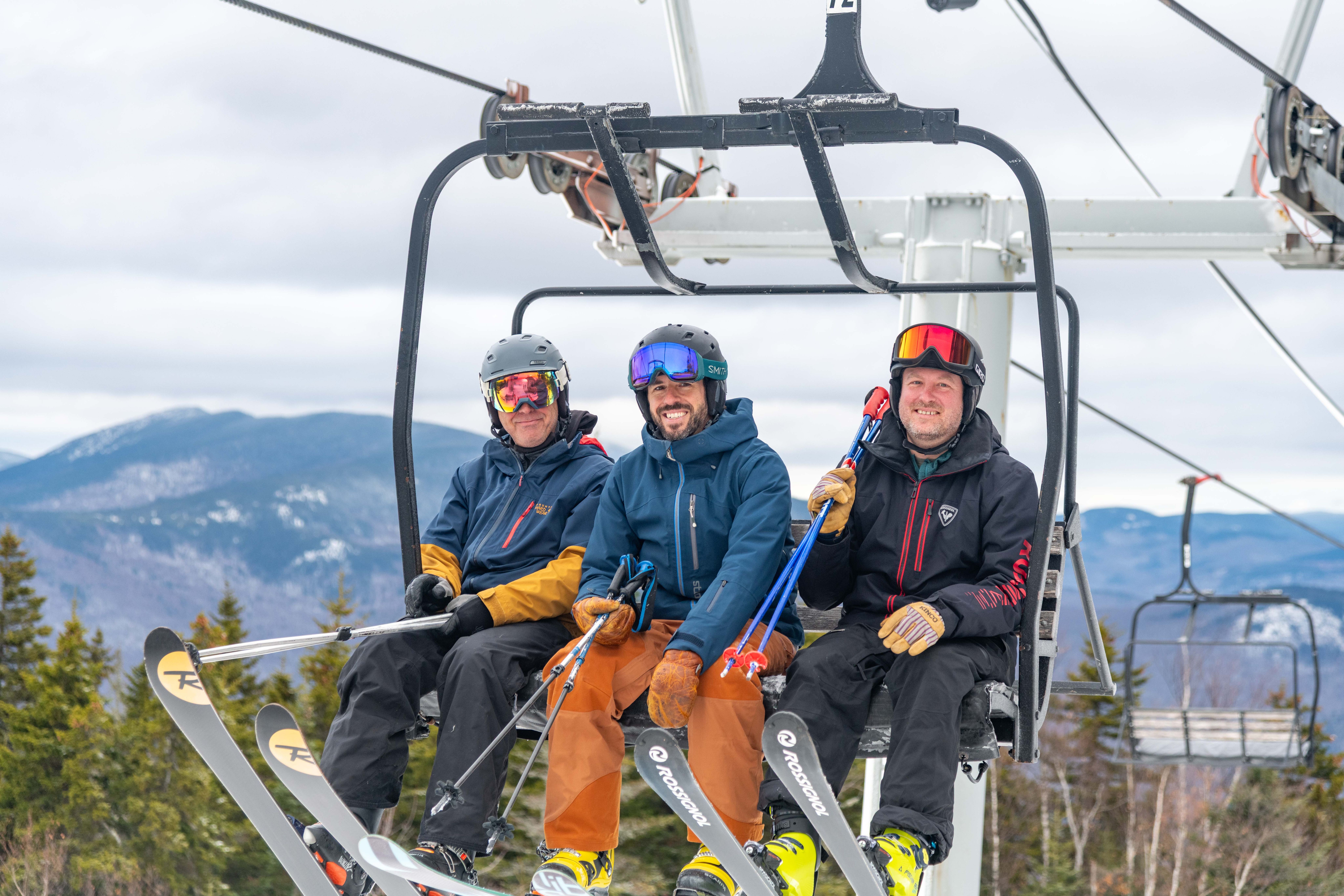 People sitting in a chair on a chairlift at Sunday River.