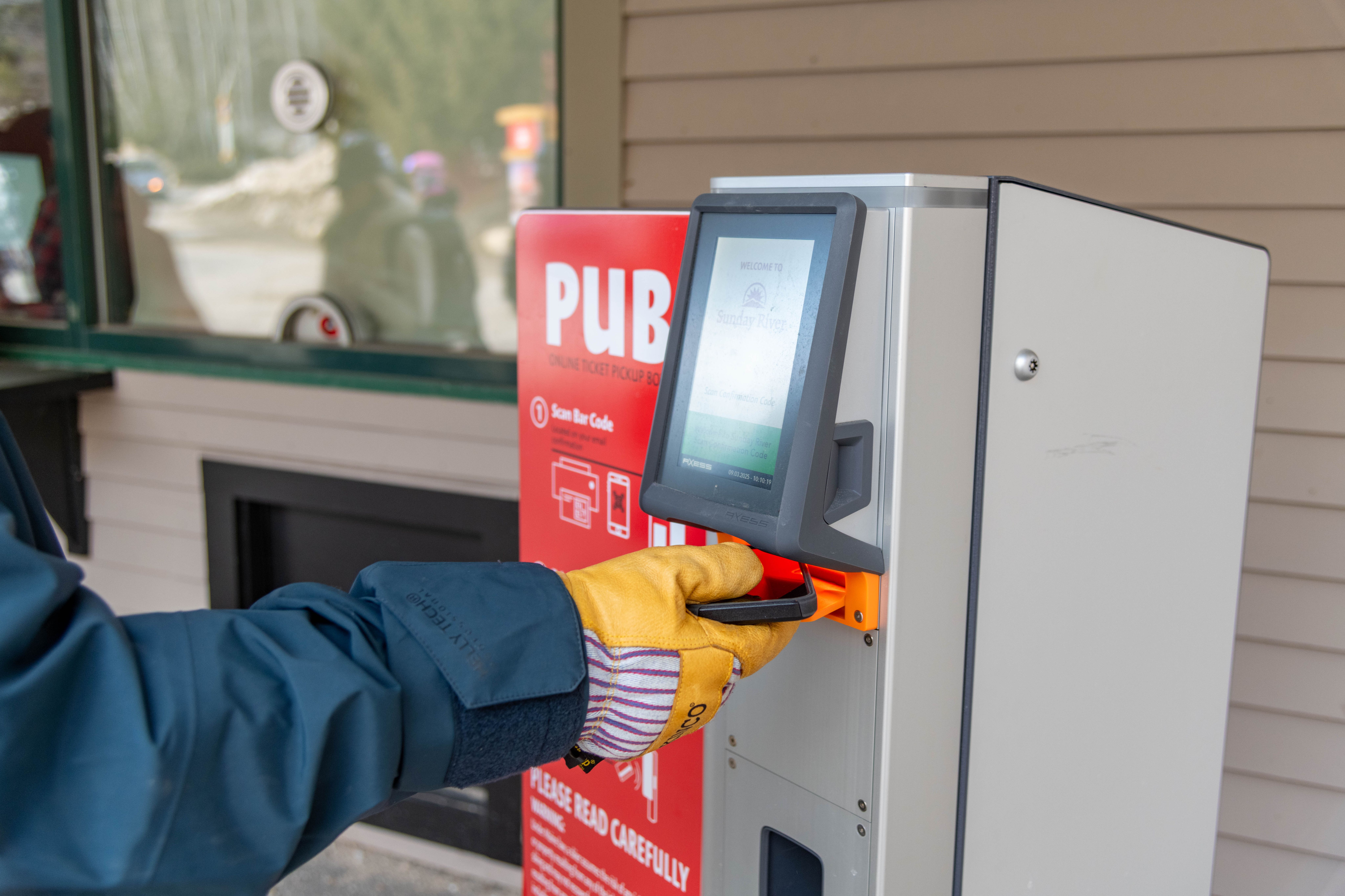 A person scanning their phone at a PUB machine to print their go card at Sunday River.