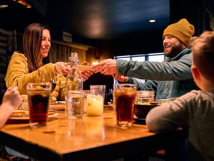 A family at Camp passing around some food at the table.