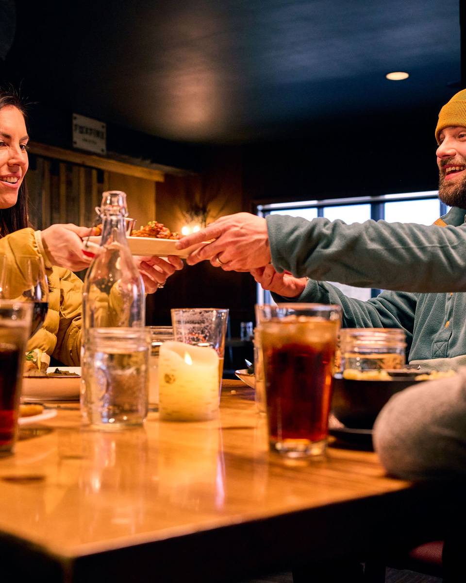 A family at Camp passing around some food at the table.