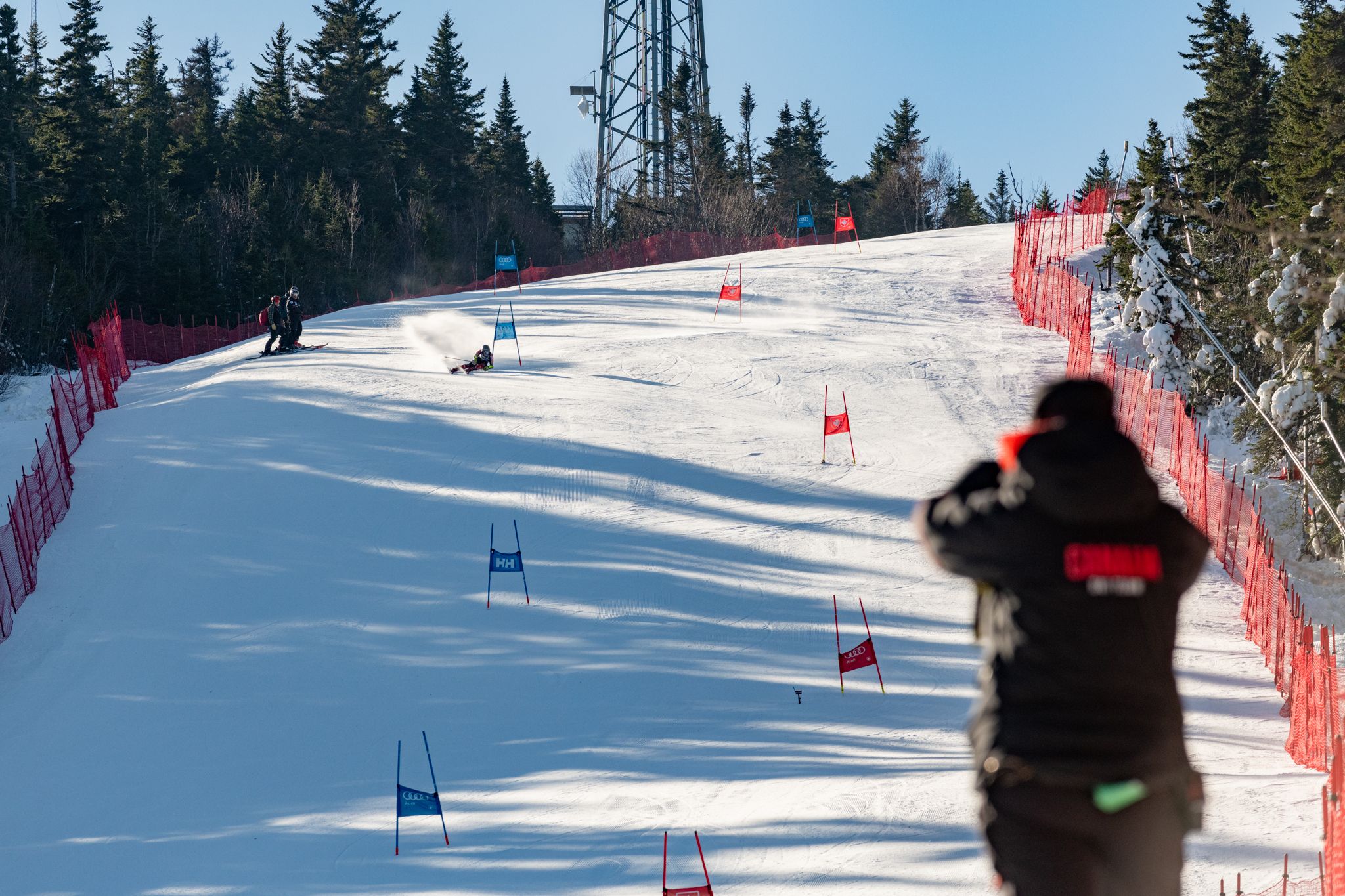 A person watching a race with binoculars at Sunday River.