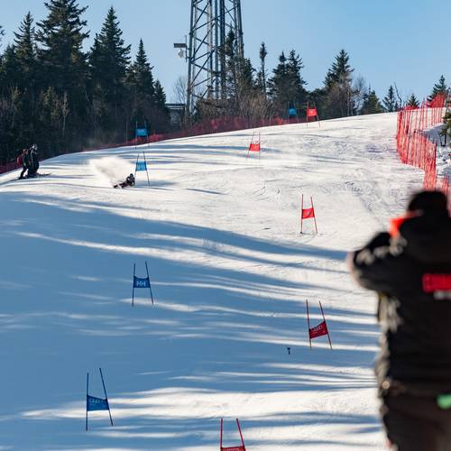 A person watching a race with binoculars at Sunday River.