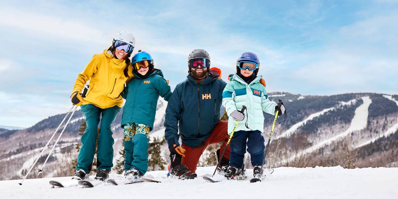 A family posing for a picture with mountains behind them.