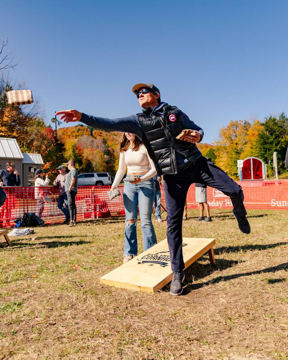 A person tossing a bean bag during a game.