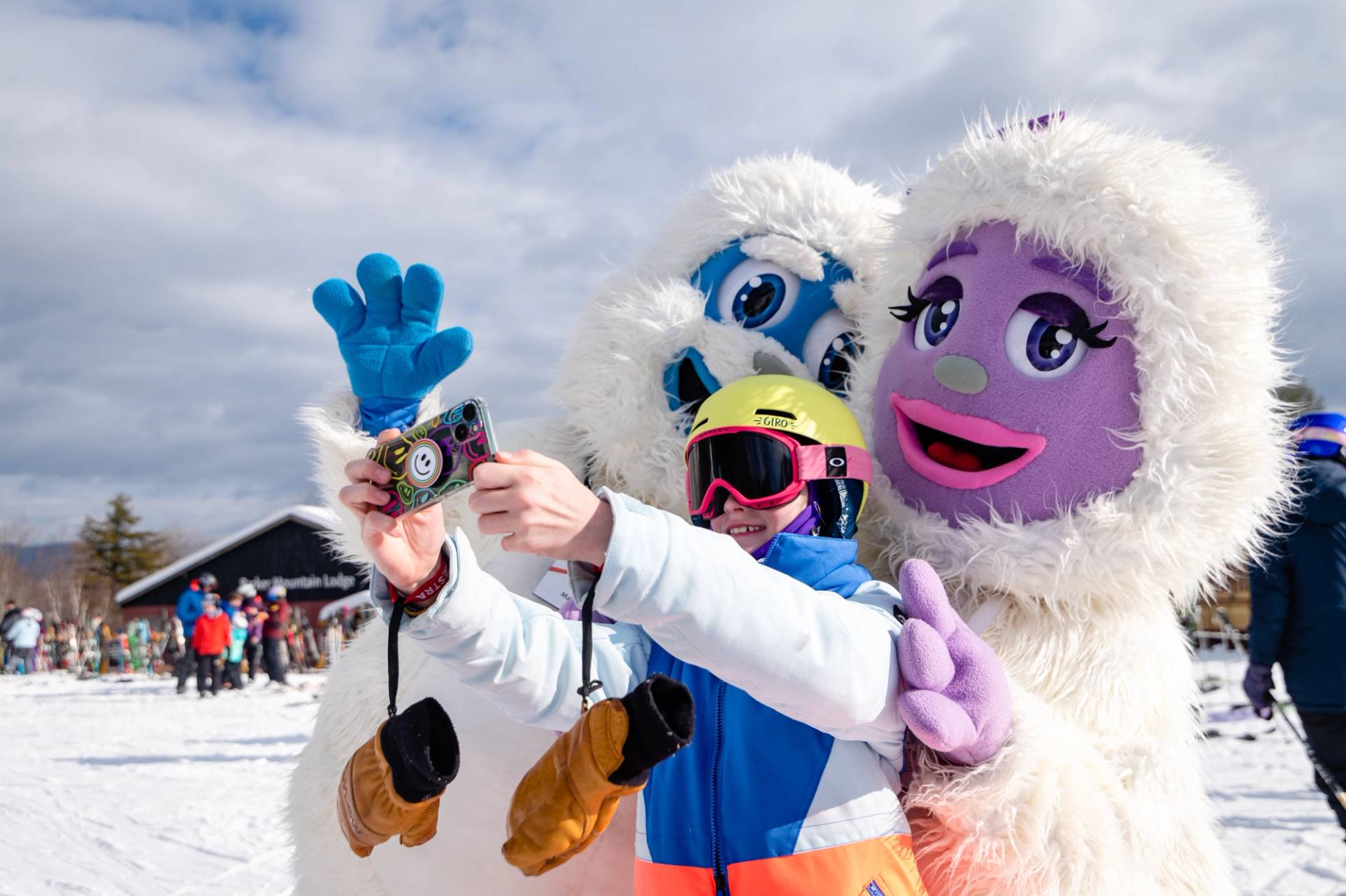 Eddy and Betty the Yetis posing for a picture with a young kid. 