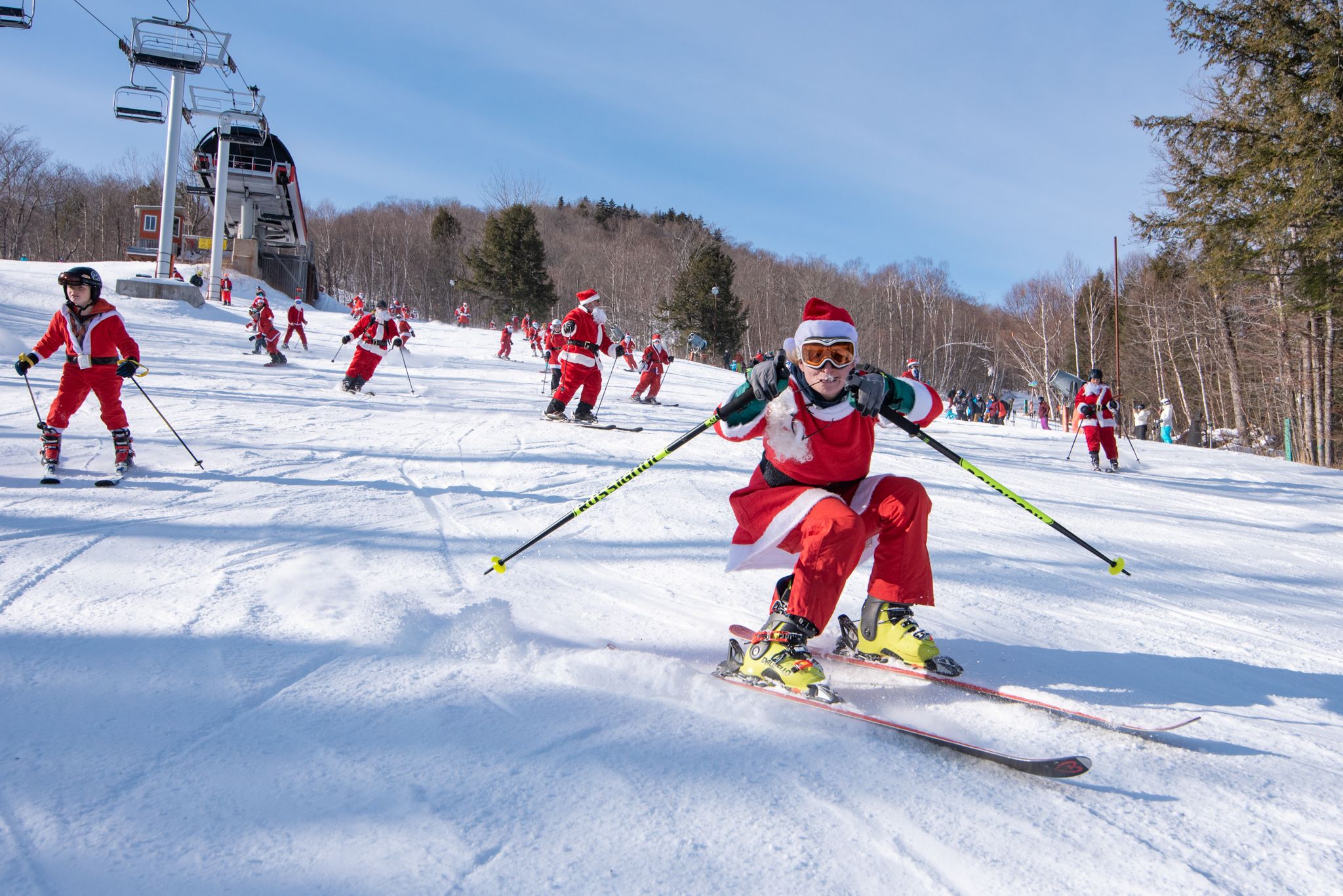 Skier dressed as Santa skiing on corduroy.
