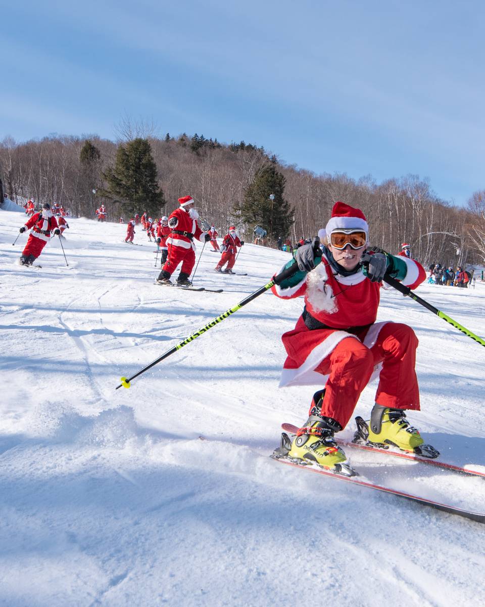 Skier dressed as Santa skiing on corduroy.