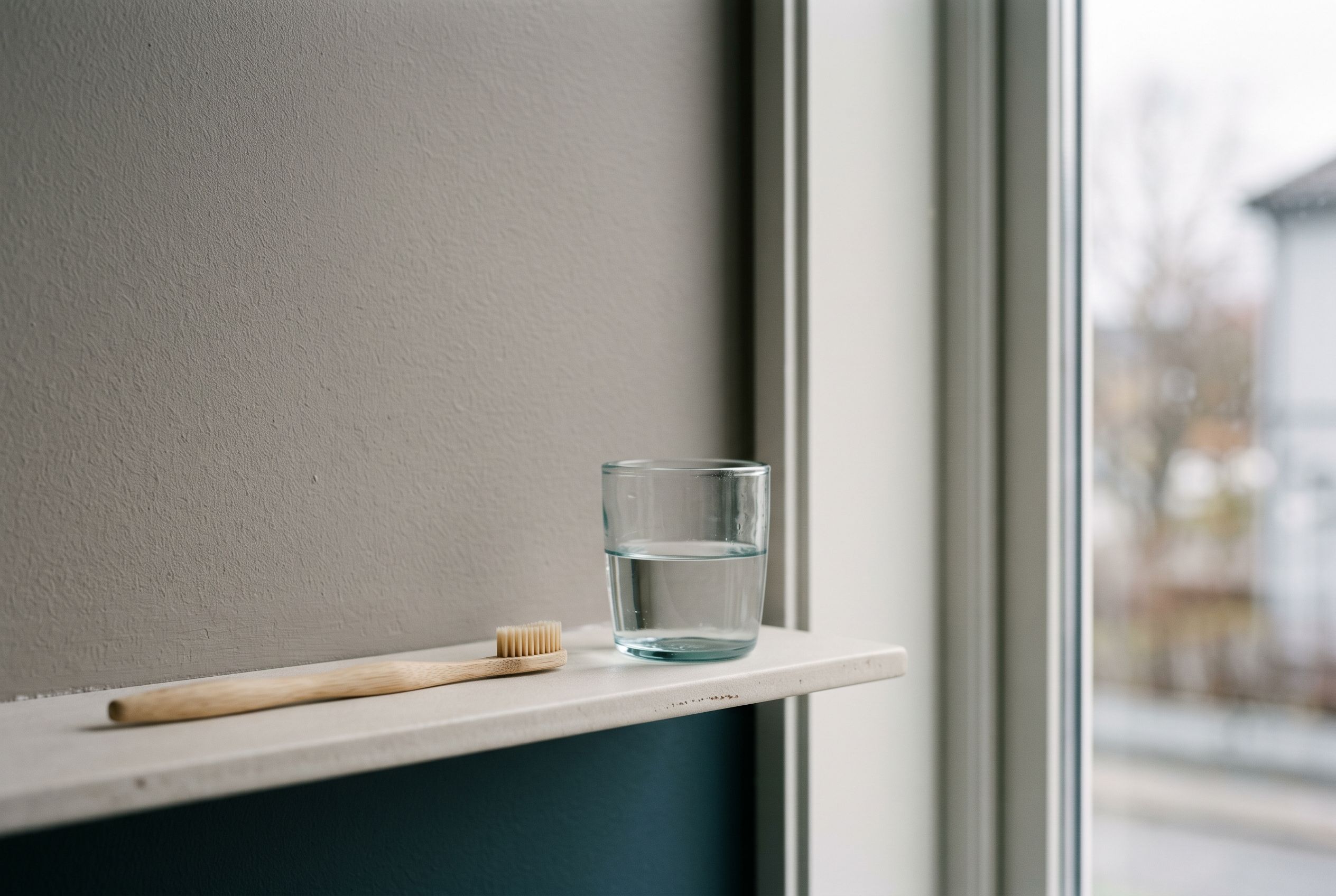 Tannbørste og glass vann i morgenlys