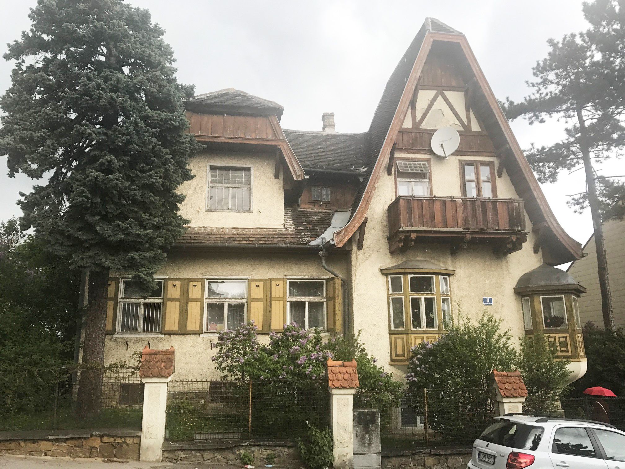 altes Haus mit Bäumen und Auto davor