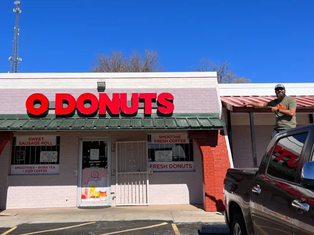 The O Donuts storefront beneath a bright blue sky.